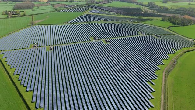 Top down aerial view of a geometric solar array and power inverter blocks, showcasing industrial symmetry and clean energy generation infrastructure in Tutbury, UK.
