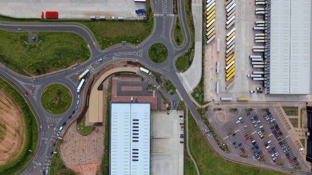 Top down aerial view of large distribution warehouses and HGVs at loading bays UK