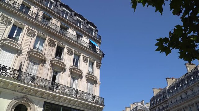 Typical Parisian residential facade and iron wrought balconies on a sunny summer day, Paris, France.