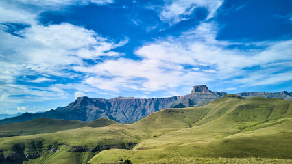 Fototapeta premium Aerial View Rolling South African Highlands, Vivid Green Slopes And Sweeping Plateau Leading To Jagged