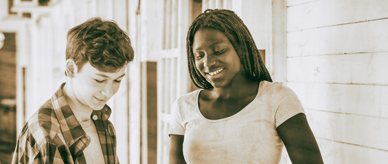 Caucasian boy and african girl at school smiling together © jovannig