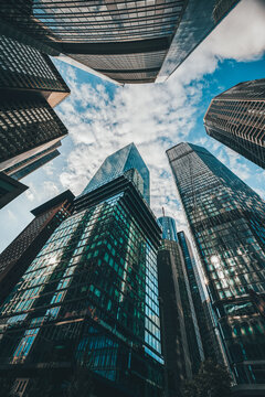 View of towering skyscrapers reaching towards the heavens, their glass facades reflecting the azure sky above in Frankfurt, Hessen, Germany.