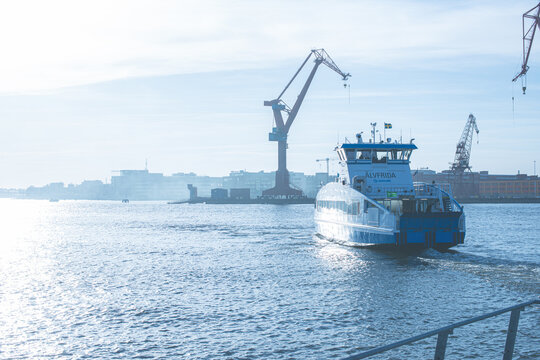 Gothenburg, Sweden - April 03 2017: Passenger ferry ?lvsnabben ?lvfrida crossing Gothenburg harbor with industrial cranes in background.