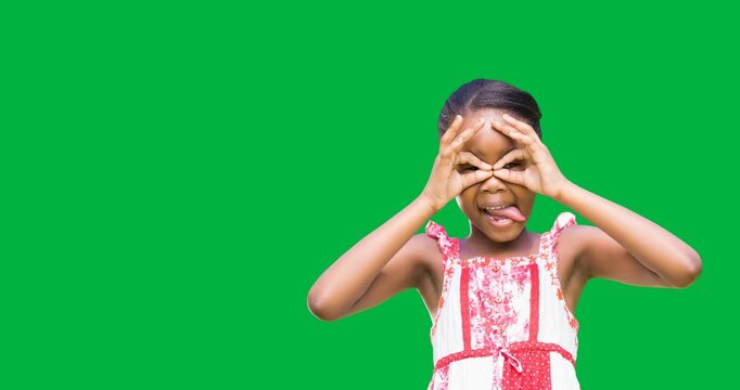 African american girl making a face mask with her hands against black background