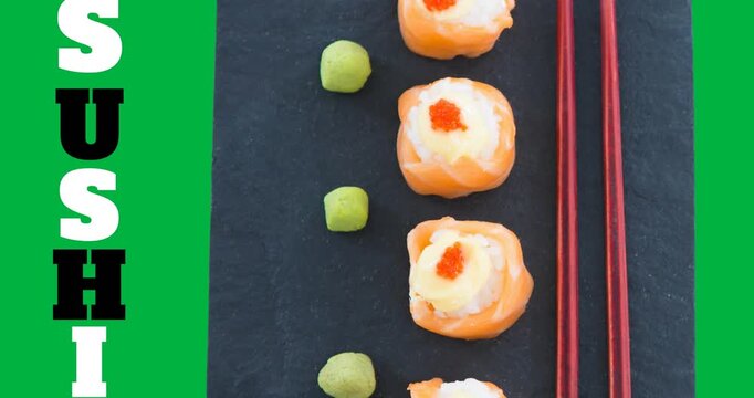 Sushi text with sushi and chopsticks in a plate on black surface