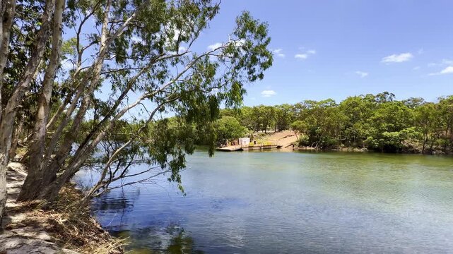 Cinematic shot of a vehicle ferry crossing the Jardine River in Cape York, northern Queensland, Australia. Remote tropical river crossing in rugged outback landscape.