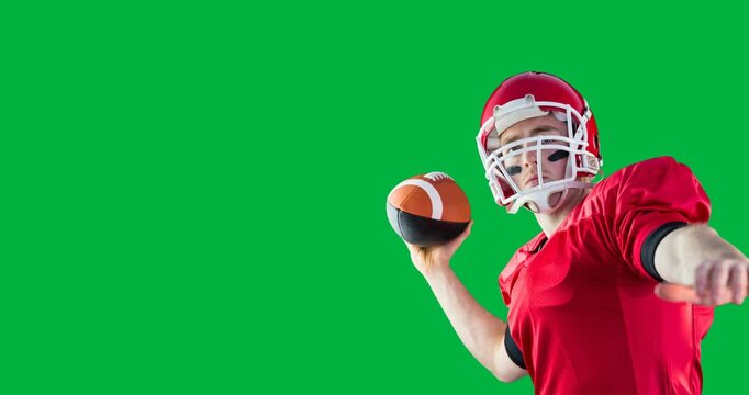 Caucasian male rugby player wearing a helmet throwing a rugby ball against black background