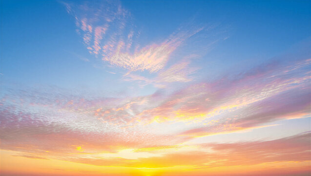 Glowing yellow sunset with textured clouds over blue sky background atmosphere