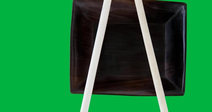 Sushi text banner with chopsticks on a plate against black background