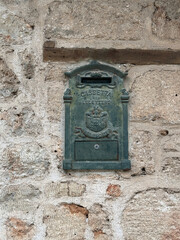Vintage metal mailbox on rustic stone wall, suitable for backgrounds or historical themes © dvoevnore