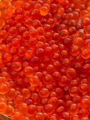 Close-up of vibrant red salmon roe, creating a textured and colorful background © dvoevnore
