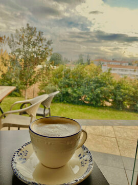 Cozy bir g&uuml;nde k&ouml;p&uuml;kl&uuml; kahve fincanı, bah&ccedil;e manzaralı.