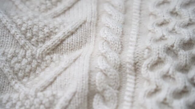 Macro shot of wool fabric sweater. Slider dolly close-up wool textile beige color texture. Detailed knit material