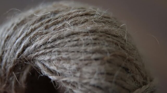 Hand hold natural jute twine, showcasing its rough fibers and organic weave. The earthy tones and intricate details make it perfect for rustic, eco-friendly, and craft-related projects.