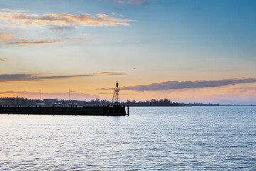 Obraz premium Amazing sunset seen from the pier of the city of Rorschach over Lake Constance in the Sankt Gallen region in Switzerland with an impressive rolling cloudscape full of unpredictable weather and snow sh