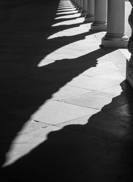 Black and White Shadow Patterns Across Historic Stone Colonnade Floor