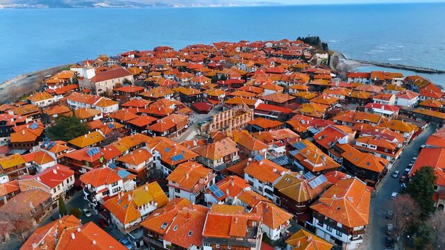 Aerial view of ancient church ruins among red houses. High angle shot of historical stone basilica ruins in old town