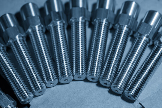 A creative arrangement of metal screws organized in a half-circle shape on a blue-toned industrial background.
