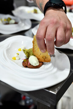 chef emplatando plato de postre con ingredientes como tota crujiente, helado, pistacho
