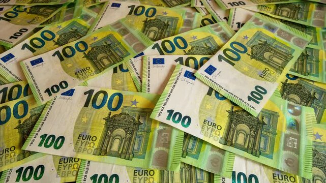Pile of one hundred euro banknotes on wooden table. Cash background representing wealth, success and financial profit, 4k