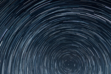 Fototapeta premium Concentric Star Trails Rotating Around the North Celestial Pole in Deep Blue Night Sky