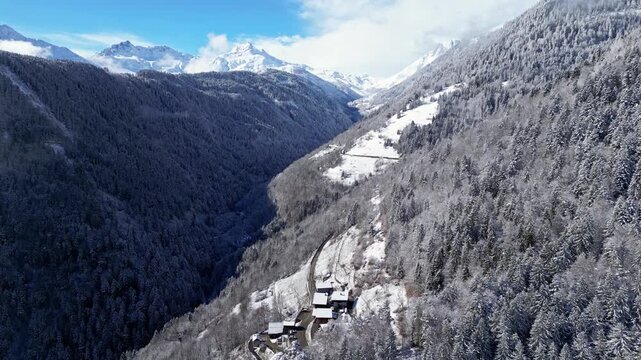 Snow covered alpine village in Tarentaise Valley with traditional houses and mountain scenery in the French Alps, Savoie, France.