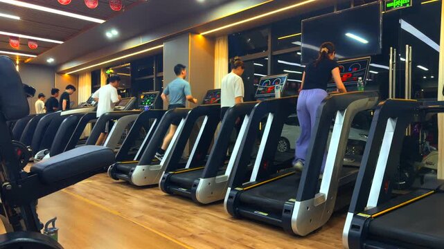 Modern urban gym interior, people running on treadmills, active cardio workout scene, energetic fitness atmosphere or health, wellness, and active lifestyle commercial projects