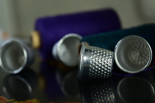 Close-up of thimbles and colored spools of thread