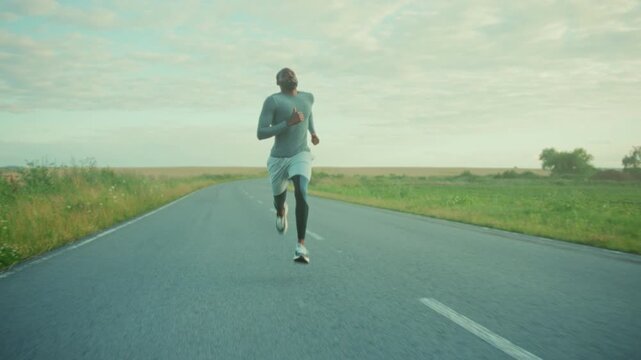 Morning marathon training on quiet roadway, Athlete pushes limits during sunrise run on peaceful road