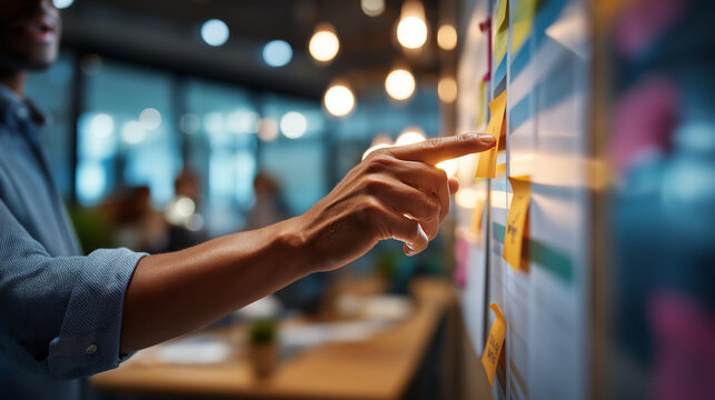 Close up of hands at a bright office conducting a wip limit review at a kanban board a hand pointing at a column that has exceeded its work in progress limit with an alert