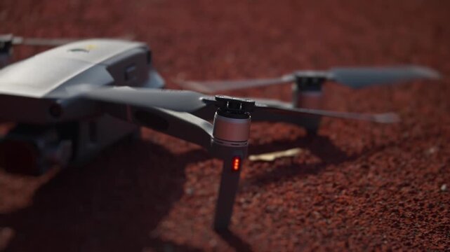 Drone motors start up before lifting off and exiting frame in slow motion
