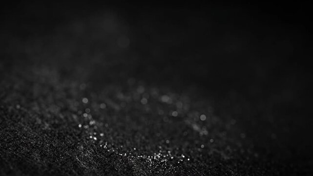 Close up macro shot of a fingerprint on a dark textured surface.