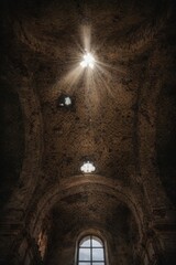 Naklejka premium Sunlight Streaming Through Ruined Church Ceiling