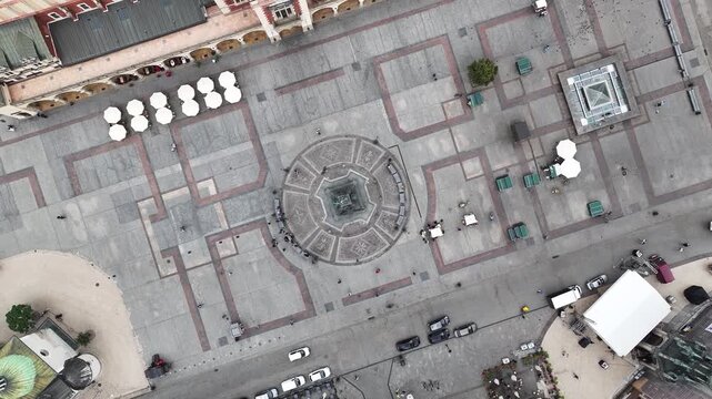 High Altitude Top Down Drone 360 Rotation over Adam Mickiewicz Monument with People and Movement, Krakow Main Market Square, Poland, 4K 60fps