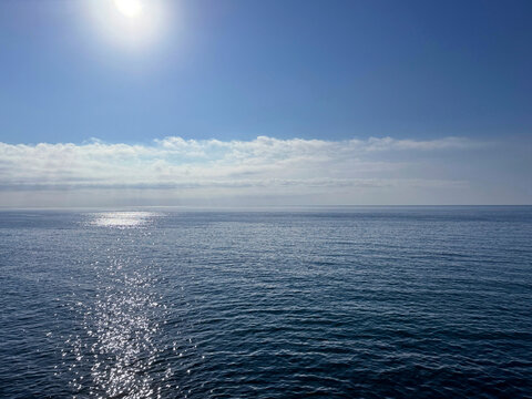 Open sea, blue sky and sun.