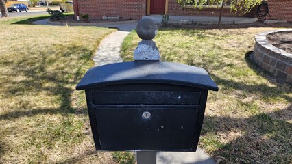 Obraz premium a plan black mailbox in front of a brick house