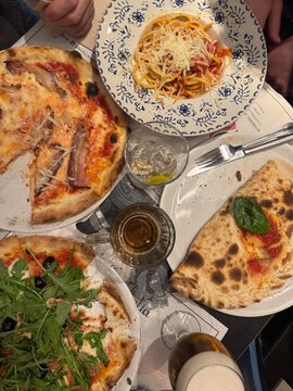 Italian dinner table with pizza pasta and calzone