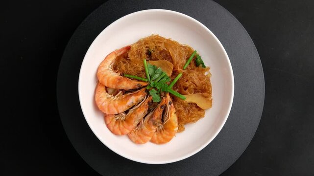 Casseroled Shrimps with Glass Noodles, Shrimp potted with vermicelli in white plate.(goong ob woon sen).Top view.