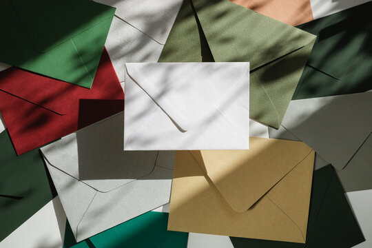 Full frame overhead view of assorted multi coloured envelopes on a table in dappled light