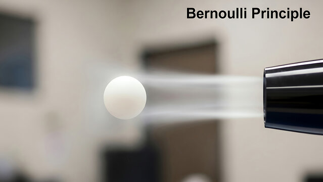 A white ball is being blown away from a black nozzle in an indoor setting with a blurred background using the Bernoulli Principle.