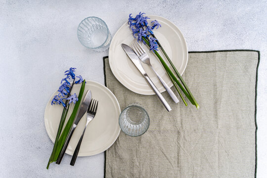 Overhead view of two rustic spring place settings with fresh blue hyacinths on a table