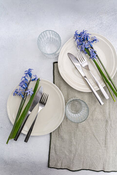 Overhead view of two rustic spring place settings with fresh blue hyacinths on a table