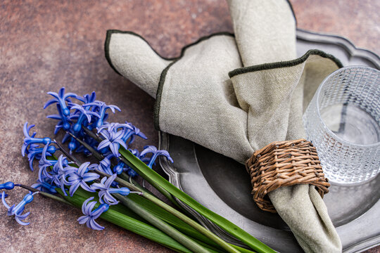 Close-up of a rustic spring place setting with fresh blue hyacinths on a table