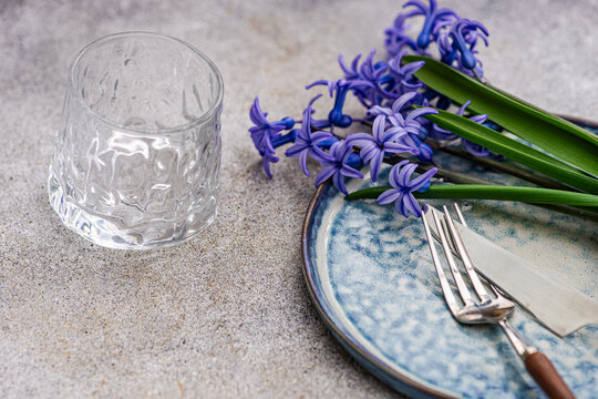 Close-up of a rustic spring place setting with fresh blue hyacinth flowers