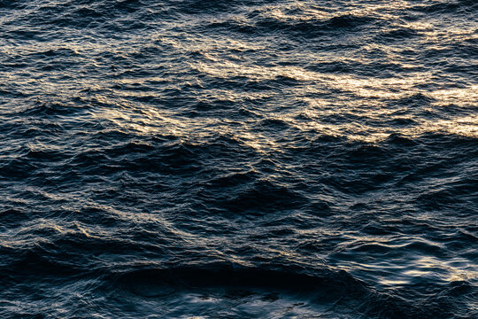 Sunlit ocean surface with rolling waves and textured water