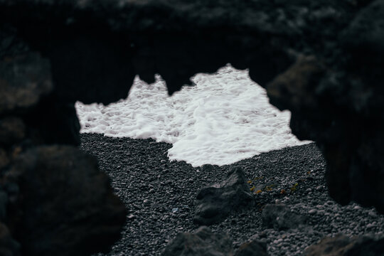Atlantic wave foam on black pebble beach, La Palma