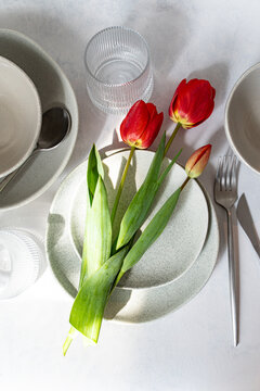 Overhead view of red tulips on a place setting on a table