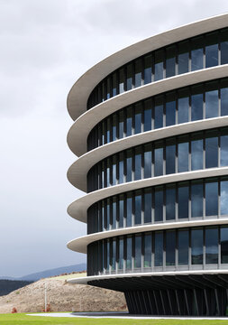 Modern curved office building facade with glass and sky