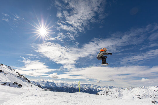 Snowboarder jumping on a sunny winter day in Pyrenees
