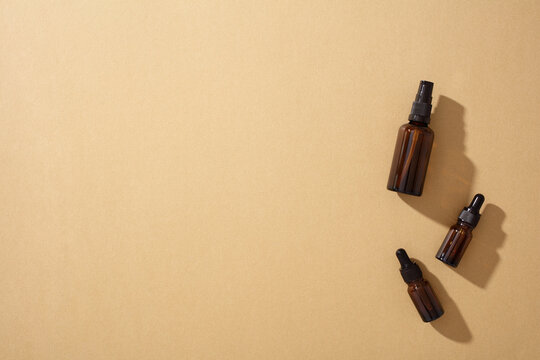 Eco-friendly cosmetics in glass bottles on brown background